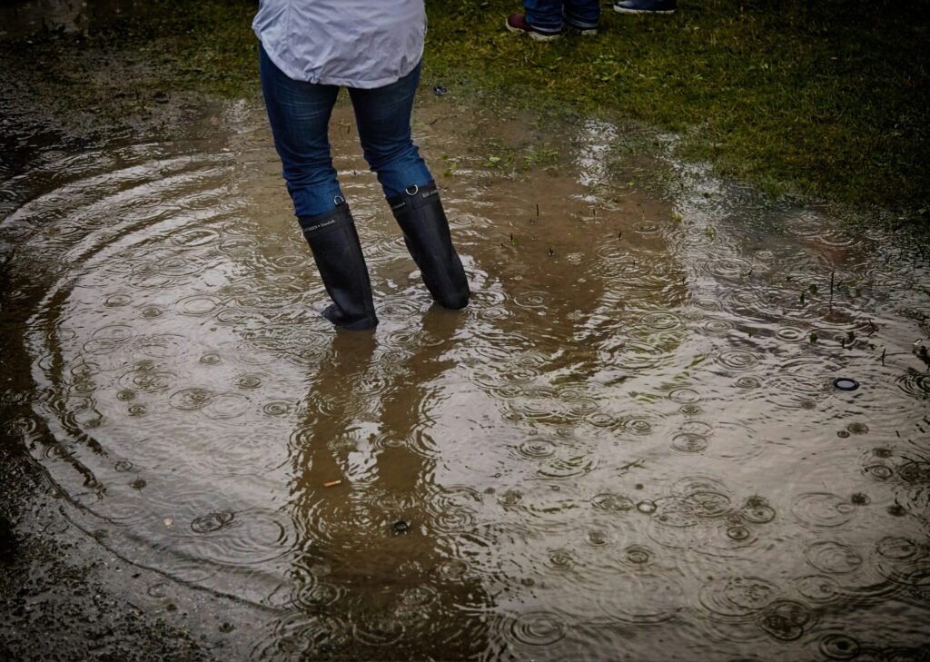 person walking in water in boots